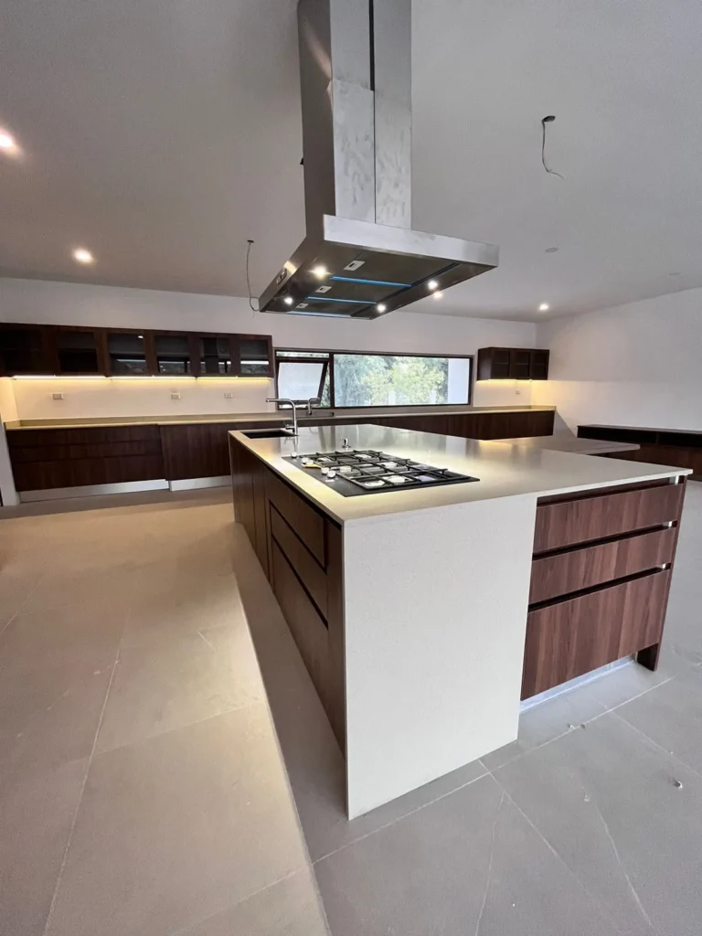 Cocina contemporánea en madera con isla central, encimera y campana suspendida