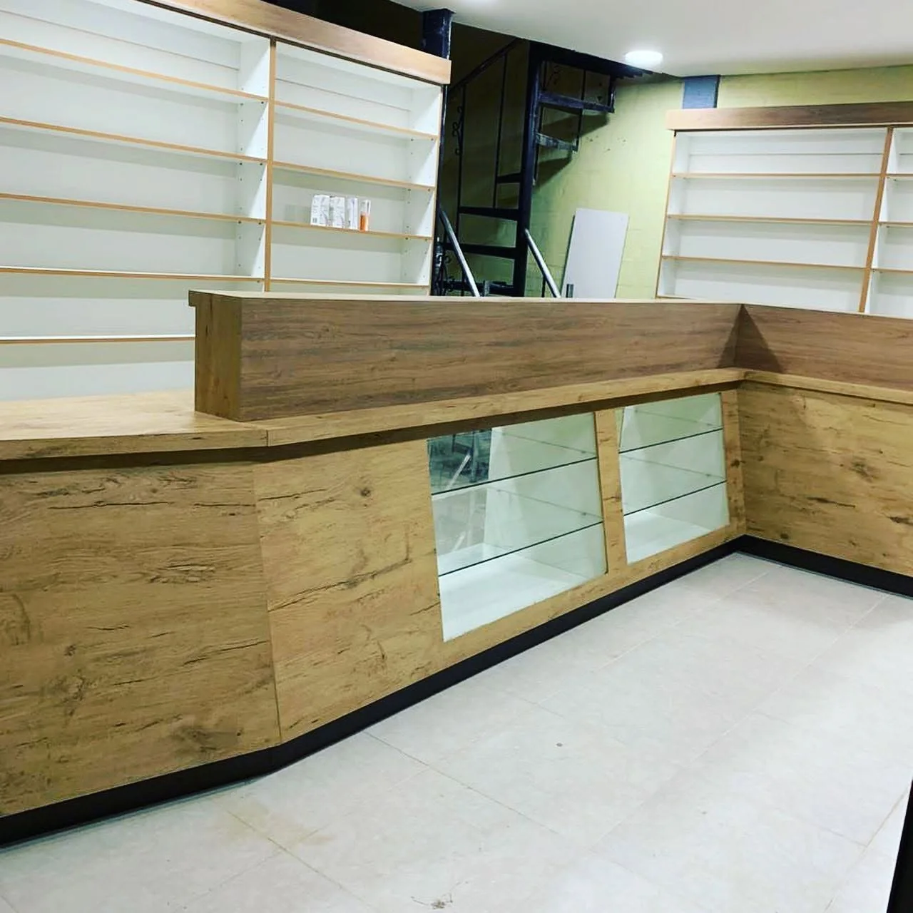 Mostrador en madera con vitrinas de vidrio y estanterías de exhibición